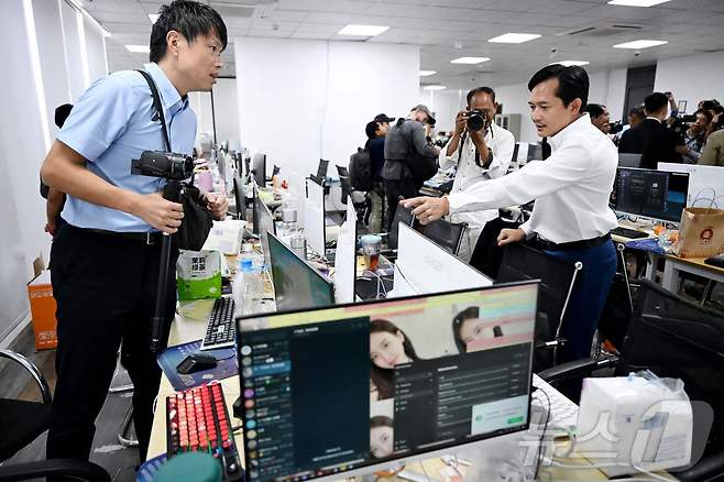 텝 아스나릿 캄보디아 정보부 차관 겸 대변인이 3월 프놈펜 사이버 사기 센터에서 압수된 모니터를 살펴보고 있다. 2026.3.11 ⓒ AFP=뉴스1