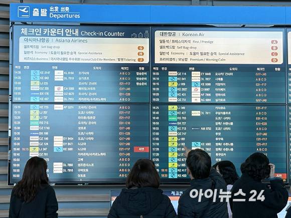 지난 1월 17일 출국객들이 체크인 카운터 인근에서 안내 전광판을 확인하고 있다. [사진=권서아 기자]