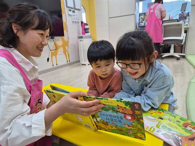 지난 21일 경북 고령군 고령소방서 내 '119아이행복돌봄터'에서 돌보미들과 함께 아이들이 그림책을 읽고 있다. 김정석 기자