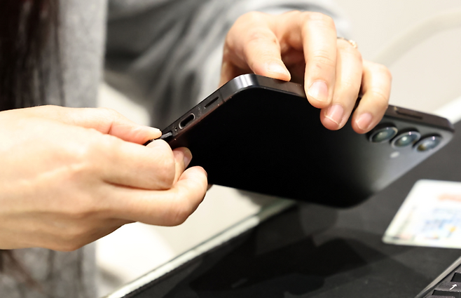 LG유플러스 직원들이 13일 매장에서 고객의 유심을 무상으로 교체해 주고 있다. [연합뉴스]