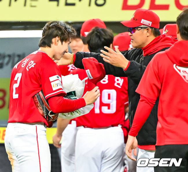 [OSEN=대구, 민경훈 기자] 21일 오후 대구삼성라이온즈파크 ‘2026 신한 SOL Bank KBO리그' 삼성 라이온즈와 SSG 랜더스와 경기가 열렸다.이 경기에서 SSG는 연장 10회 박성한의 결승타에 힘입어 5-4로 이겼다. 박성한은 1회 첫 타석에서 안타를 추가하며 개막 후 19경기 연속 안타를 때려내며 44년 만에 이 부문 신기록을 세웠고 결승타의 주인공이 됐다.경기를 마치고 박성한이 이숭용 감독에게 꽃다발을 받고 있다. 2026.04.21 / rumi@osen.co.kr