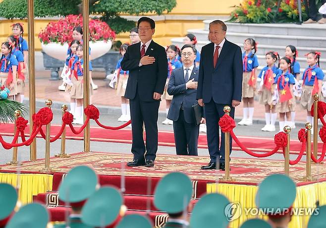 국기에 경례하는 이재명 대통령 (하노이=연합뉴스) 김도훈 기자 = 베트남을 국빈 방문한 이재명 대통령이 22일(현지시간) 하노이 주석궁에서 열린 공식환영식에서 국기에 경례하고 있다. 오른쪽은 또 럼 공산당 서기장 겸 국가주석 2026.4.22 superdoo82@yna.co.kr