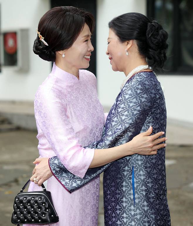 김혜경 여사와 또 럼 베트남 당 서기장 겸 국가주석 부인 응오 프엉 리 여사가 23일(현지 시간) 베트남 하노이 민족학 박물관에서 열린 친교 일정에서 포옹하고 있다.김 여사가 착용한 옷은 응오 프엉 리 여사가 선물한 베트남 전통 의상 아오자이다./뉴시스