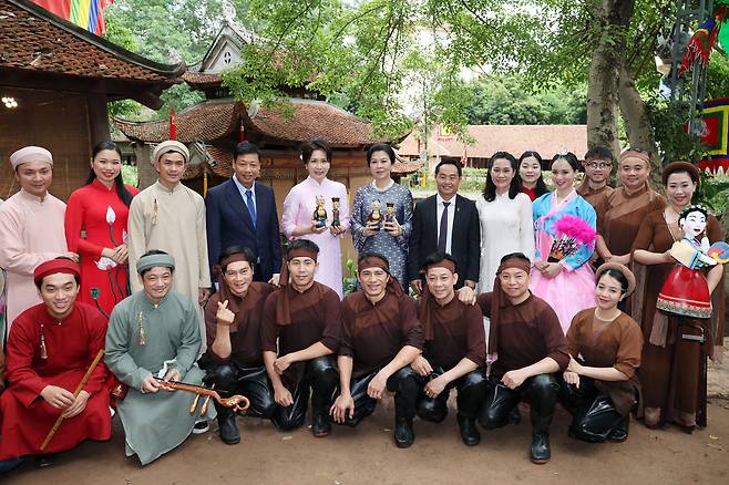 김혜경 여사와 또 럼 베트남 당 서기장 겸 국가주석 부인 응오 프엉 리 여사가 23일(현지 시간) 베트남 하노이 민족학 박물관에서 열린 친교 일정에서 참석자들과 기념촬영을 하고 있다.김 여사가 착용한 옷은 응오 프엉 리 여사가 선물한 베트남 전통 의상 아오자이다./뉴시스