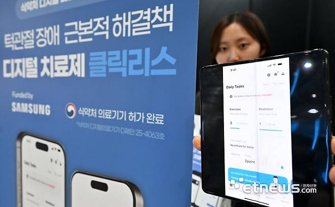 국내 최고 정보통신기술(ICT) 축제 '월드IT쇼 2026'이 22일 서울 강남구 코엑스에서 사흘 일정으로 열렸다. 개막 이튿날인 23일 비욘드메디슨 부스에서 관람객이 턱관절 장애 디지털 치료제 클릭리스를 선보이고 있다. 김민수기자 mskim@etnews.com