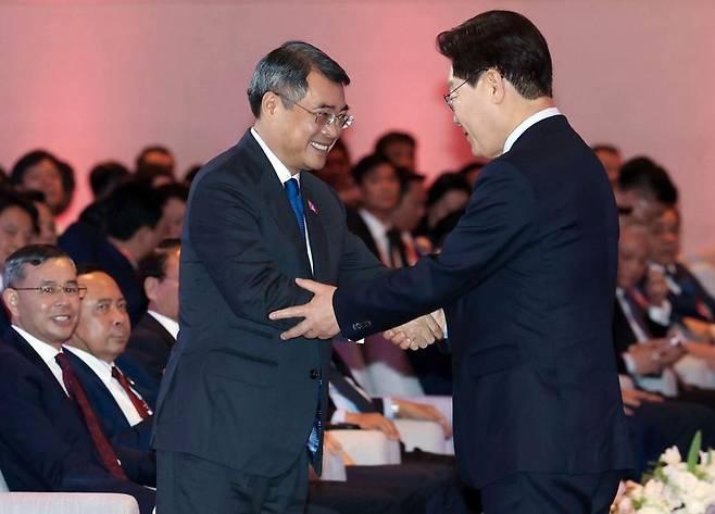 이재명 대통령이 23일 베트남 하노이 한 호텔에서 열린 한-베트남 비즈니스 포럼에서 발언을 마친 후 레 민 흥 베트남 총리와 악수하고 있다. 연합뉴스