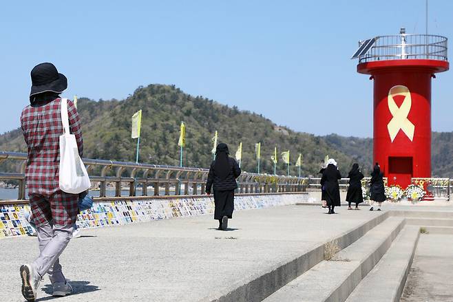 세월호 참사 12주기인 지난 16일 오전 전남 진도군 임회면 팽목항에서 추모객들이 꽃이 놓여진 등대로 이동하고 있다. 연합뉴스