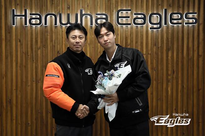 <yonhap photo-4761="">투수 엄상백(오른쪽)이 8일 대전 중구 한화 이글스파크에서 한화 이글스와 FA 계약을 한 후 손혁 단장과 기념 촬영하고 있다. 사진=한화 제공</yonhap>