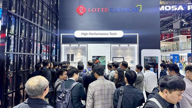 '차이나 플라스 2026' 관람객들이 지난 21일 롯데케미칼 부스에서 반도체 등 첨단 기술 분야 제품을 살펴보는 모습. 롯데케미칼 제공