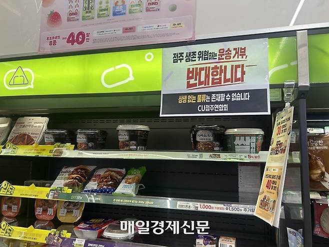 23일 오전 방문한 경기 부천의 한 CU 점포 간편식 매대에 ‘점주 생존 위협하는 운송거부, 반대합니다’라고 적힌 피켓이 걸려있다. [변덕호 기자]