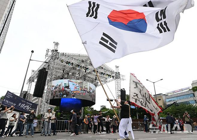 [광주=뉴시스] 이영주 기자 = 5·18민주화운동 45주기 전야제가 열리는 17일 오후 광주 동구 금남로에서 5·18민주화운동 45주기를 기념하는 풍물패가 대형 태극기를 흔들고 있다. 2025.05.17. leeyj2578@newsis.com