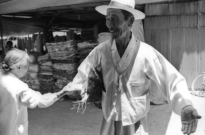 장에서 동무를 만나 국밥 집에 가자는 할머니.1988 전북 순창장./ 사진가 정영신