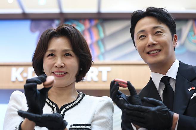 이재명 대통령과 베트남을 국빈 방문 중인 김혜경 여사가 23일 하노이 롯데몰에서 열린 K문화관광대전에서 배우 정일우와 직접 만든 마카롱을 들어보이고 있다. /뉴스1