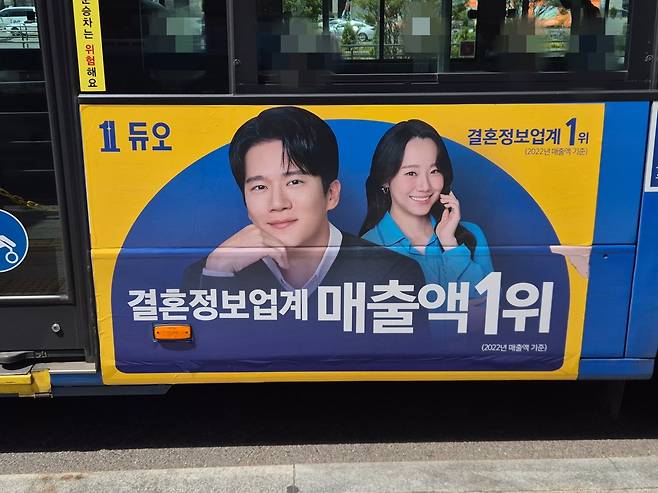 23일 정오 무렵 서울 중구 서울역버스환승센터를 지나는 한 버스회사의 시내버스 차량에 결혼정보회사 ‘듀오’ 광고가 보인다. 김동환 기자
