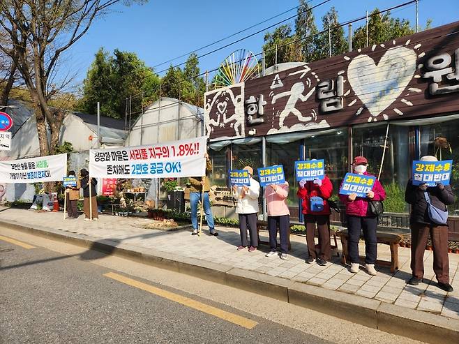 13일 서울 서초구 우면동성당 앞에서 송동마을 주민들이 강제수용을 반대하는 피켓 시위를 벌이고 있다. [조병연 기자]