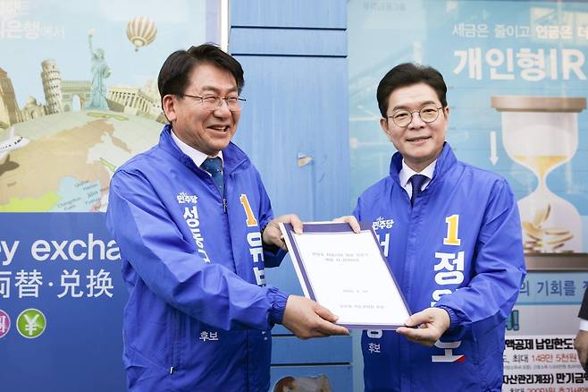민주당 유보화 성동구청장 후보(왼쪽)가 24일 성수동에서 정원오 서울시장 후보를 만나 지역 개발 건의사항을 전달하고 있다.