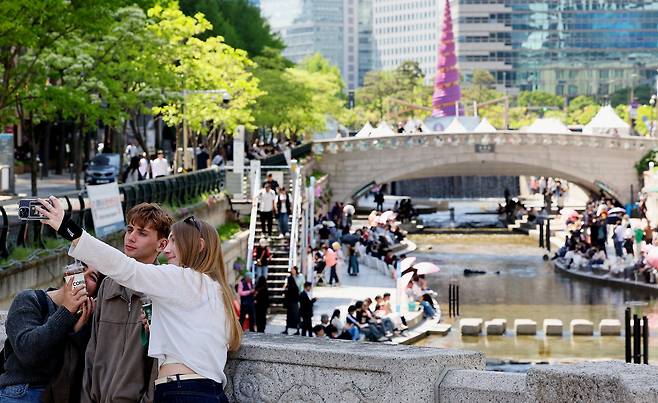 낮 최고기온이 26도까지 오르며 초여름 날씨를 보인 지난 24일 오후 서울 청계천을 찾은 외국인 관광객들이 더위를 식히고 있다. 뉴스1