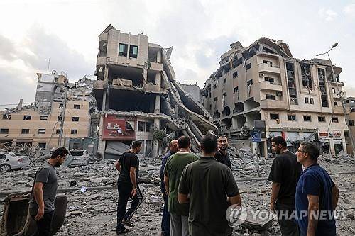 팔레스타인 사람들이 이스라엘의 공습을 받은 가자 지구 파괴 현장을 둘러보고 있다. [사진=연합뉴스]