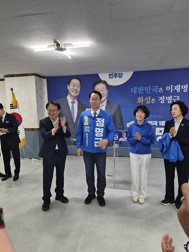 권칠승 의원이 정명근 더불어민주당 화성시장 후보에게 선거운동복을 입혀주며 응원하고 있다.<박건 기자>
