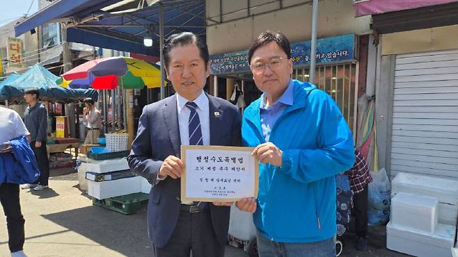조상호 세종시장 예비후보가 25일 세종시 조치원 전통시장을 찾은 정청래 더불어민주당 당대표에게 행정수도특별법 조기 제정 제안서를 전달했다. (사진=조상호 예비후보 제공)