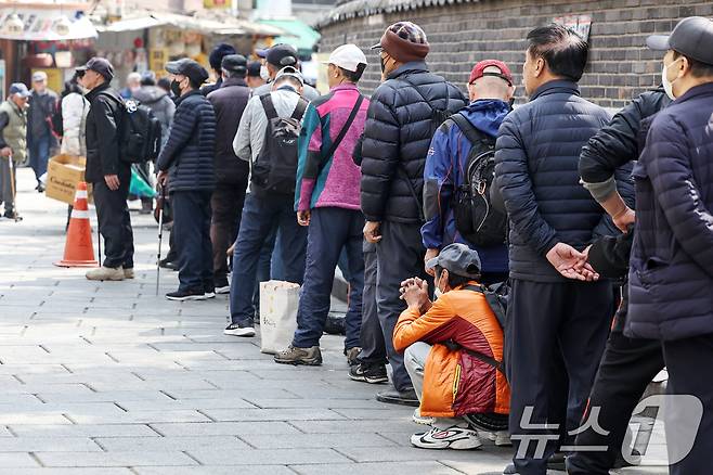 서울 종로구 탑골공원 인근 무료급식소 앞에 어르신들이 길게 줄을 서 식사 차례를 기다리고 있다.  ⓒ 뉴스1 민경석 기자