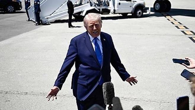 도널드 트럼프 미국 대통령이 25일(현지시간) 미 플로리다주 팜비치 국제공항에서 백악관으로 돌아가기 위해 대통령 전용기인 에어포스원에 탑승하기 전 취재진의 질문에 답하고 있다. ⓒ AFP/연합뉴스