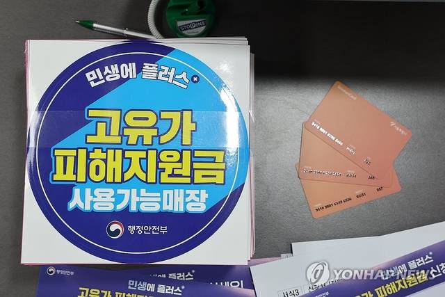 24일 서울 숭인 2동 주민센터에 마련된 고유가 피해지원금 신청 창구에 관련 부착물과 사용 카드가 놓여 있다. 고유가 피해지원금은 이달 27일부터 5월 8일까지 기초생활수급자·차상위가구·한부모가족을 대상으로 우선 지급한다. [연합뉴스]