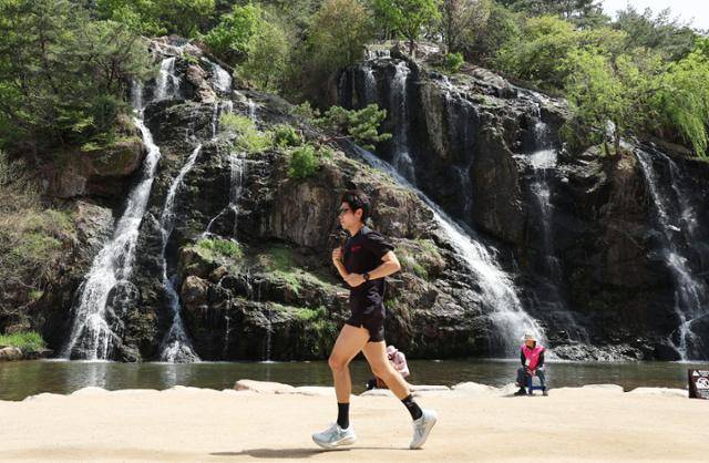 16일 서울 서대문구 홍제천 인공폭포를 찾은 시민이 가벼운 옷차림으로 달리기를 하고 있다. 뉴시스