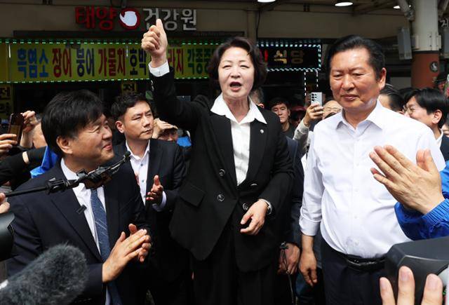 더불어민주당 추미애(앞줄 가운데) 경기지사 후보가 정청래(오른쪽) 당대표, 김용 전 민주연구원 부원장 등과 19일 경기도 성남시 모란민속5일장을 방문해 발언하고 있다. 연합뉴스