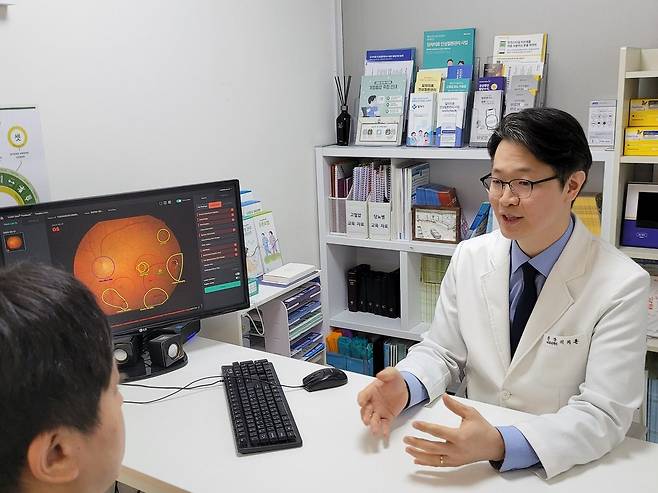 이치훈 원장이 한 환자에게 AI로 판독한 안저 검사 결과를 알려주고 있다. 그는 “만성 질환으로 실명할 수 있으니 안과 검진을 받으라고 말해도 잘 듣지 않는데, AI 눈 판독 결과에서 이상 증상이 있으니 안과에 가보라고 하면 잘 다녀온다”고 말했다. 사진= 권선미 기자