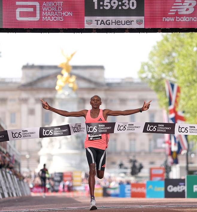 “잊을 수 없는 날” 사바스티안 사웨(케냐)가 26일 영국 런던에서 열린 2026 런던 마라톤 남자부 경기 결승선에서 두 팔을 벌리며 최초의 ‘서브 2’ 기록과 대회 2연패 달성을 자축하고 있다.  AP연합뉴스