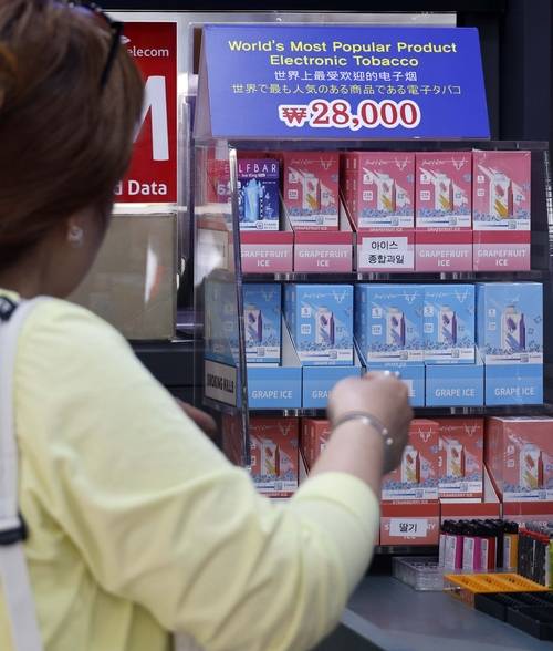 24일부터 시행되는 개정 ‘담배사업법’에 따라 전자담배를 포함한 모든 니코틴 제품이 ‘담배’로 규정되며 금연구역 내 전자담배 흡연시 과태료 10만 원이 부과되는 가운데 23일 서울 명동에서 액상형 전자담배가 판매되고 있다. [김호영기자]