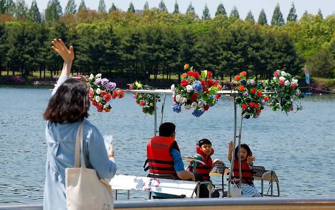 전국이 초여름 수준의 따뜻한 날씨를 보인 26일 경기 고양시 일산동구 일산호수공원에서 열린 ‘2026 고양국제꽃박람회’에서 시민들이 수상 꽃 자전거를 타고 있다.