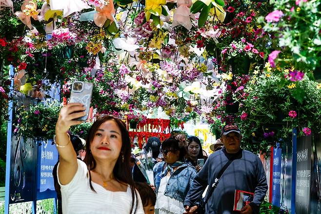전국이 초여름 수준의 따뜻한 날씨를 보인 26일 경기 고양시 일산동구 일산호수공원에서 열린 ‘2026 고양국제꽃박람회’에서 한 외국인관광객이 꽃을 배경으로 기념사진을 촬영하고 있다.