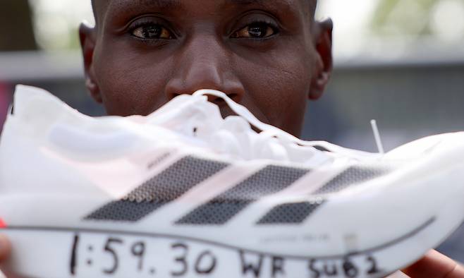 사웨가 자신의 신기록이 적힌 러닝화를 들고 포즈를 취하는 모습. 런던=AP연합뉴스