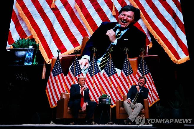 2024년 10월 31일(현지시간) 당시 미 대선 공화당 후보 트럼프 대통령의 애리조나 유세에 참석한 터커 칼슨(오른쪽) [AFP=연합뉴스 자료사진. 재판매 및 DB 금지]