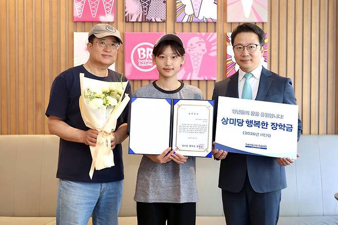 배스킨라빈스 아주대점에서 상미당 행복한 장학금 우수 장학생으로 선발된 학생(가운데)과 가맹점 대표(왼쪽), 백승훈 행복한재단 사무국장이 기념촬영을 하고 있다./사진=상미당홀딩스