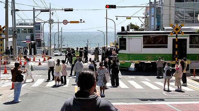 16일 오전 부산 해운대구 청사포에서 외국인 관광객들이 해변열차를 배경으로 횡단보도에 서서 기념사진을 찍고 있다./김동환 기자