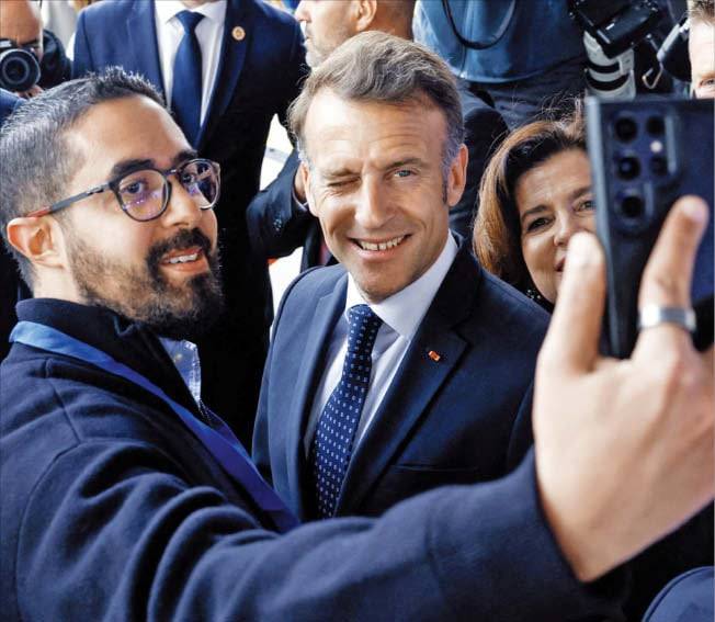 그리스 찾은 마크롱 ‘윙크’ 프랑스·그리스 경제 포럼 참석차 그리스 아테네를 방문한 에마뉘엘 마크롱(가운데) 프랑스 대통령이 한 참석자와 기념사진을 찍으며 윙크를 하고 있다. /로이터 연합뉴스