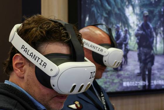 지난해 3월 일본 치바에서 열린 방산 방위 안보 장비 국제 전시회(DSEI)에서 관람객이 팔란티어 메이븐을 체험하고 있다. 로이터=연합