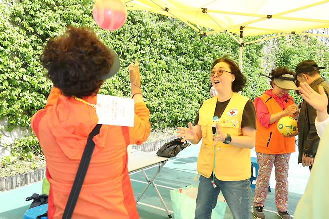 지난 15일 서울 관악구 별빛내린천 수변무대 일대에서 열린 치매안심노리터(老利攄)에서 참가자들이 ‘탱탱볼 던지며 박수치기 게임’을 하고 있다. 관악구 제공