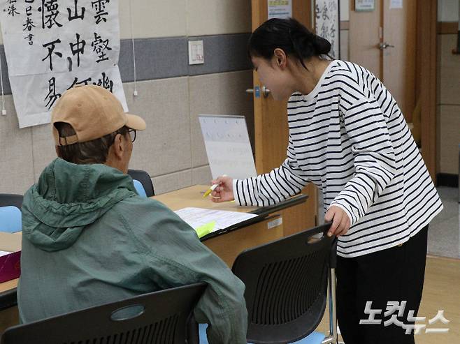 내덕2동 행정복지센터에 방문한 한 어르신이 직원으로부터 피해지원금 설명을 듣고 있다. 임성민 기자