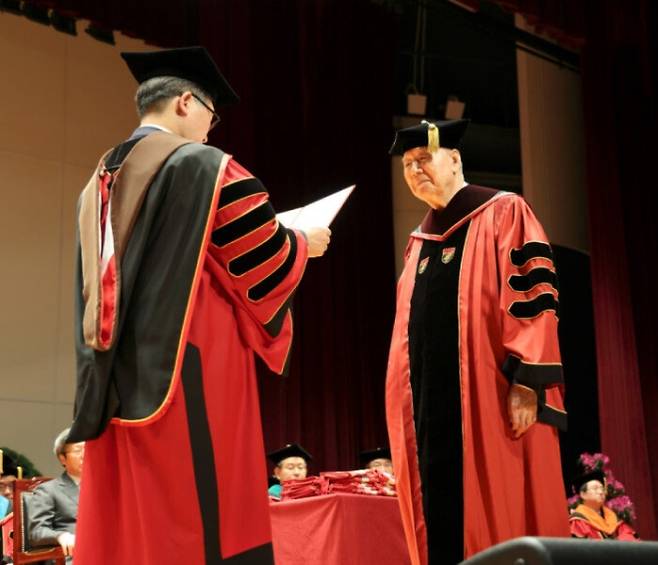 이중근(오른쪽) 부영그룹 회장이 지난 2024년 2월 23일 고려대학교 제117회 학위수여식에서 공로상과 법학 박사 학위를 받는 모습.  이 회장은 200년 고려대 정책대학원 행정학 석사를, 2004년 박사 학위를 각각 취득했고, 2022년에는 고려대 일반대학원 법학과 박사 과정에 진학해 ‘공공임대주택 관련법의 위헌성 및 개선방안에 관한 헌법적 연구’로 법학 박사 학위를 받았다. 서울신문 DB