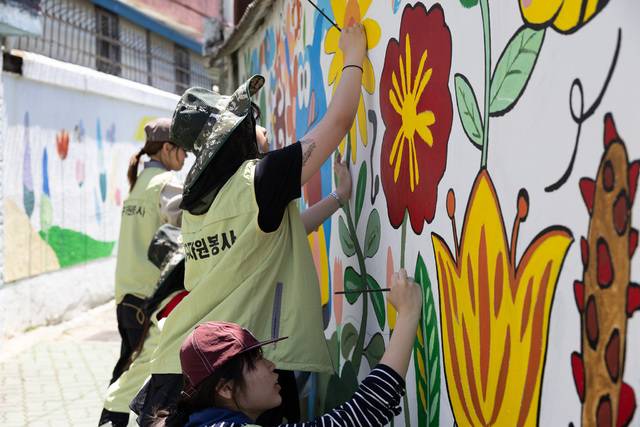 대구 자원봉사자들이 두류1·2동 일대 골목에 있는 담장에 벽화를 그리고 있다. 대구시 제공