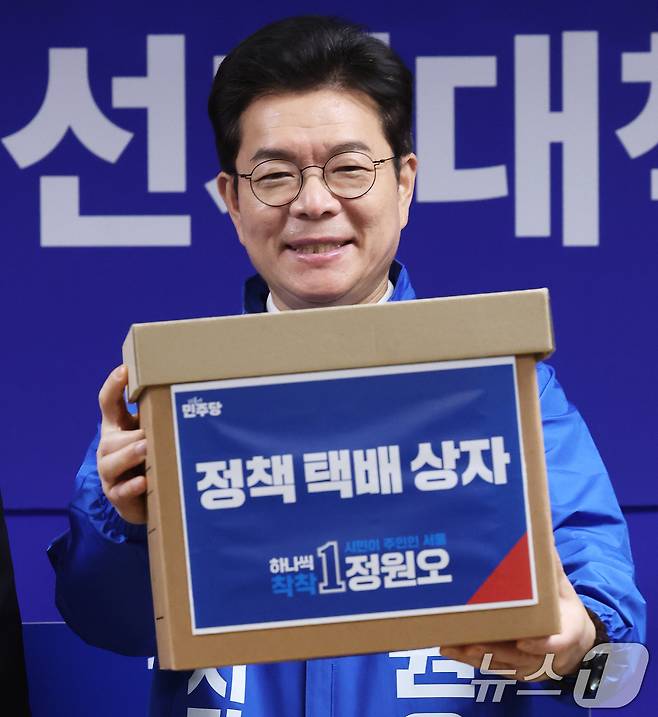 정원오 더불어민주당 서울시장 후보가 28일 서울 중구 선거대책위원회 사무실에서 열린 공개 선거대책위원회 회의에서 김형남 상임선대위원장으로부터 서울 25개 자치구 정책 공약이 담긴 택배상자를 전달받고 있다. 2026.4.28 ⓒ 뉴스1 오대일 기자