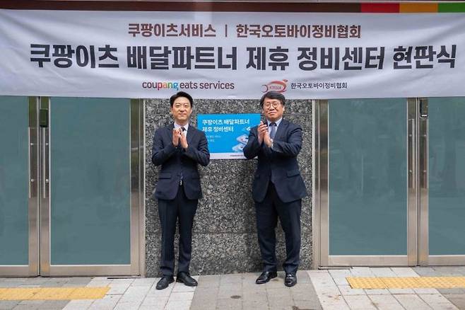 강동진 쿠팡이츠서비스 상무(왼쪽)와 이형석 한국오토바이정비협회 회장이 28일 서울 마포구 소재 쿠팡이츠서비스 제휴 정비센터에서 현판식을 기념하고 있다. 쿠팡이츠서비스