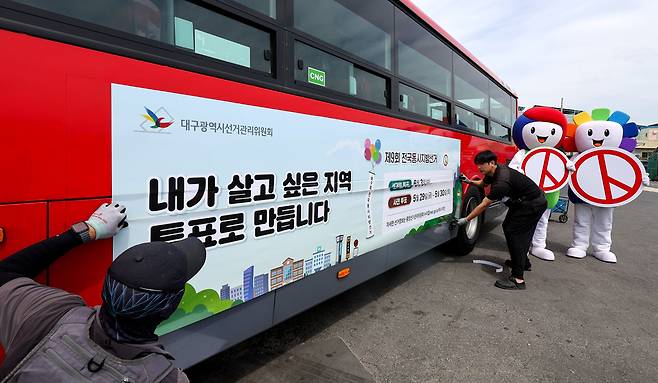 28일 대구 달서구 신흥버스 차고지에서 작업자들이 제9회 전국동시지방선거 투표 참여를 독려하는 홍보물을 시내버스에 래핑하고 있다. /뉴시스