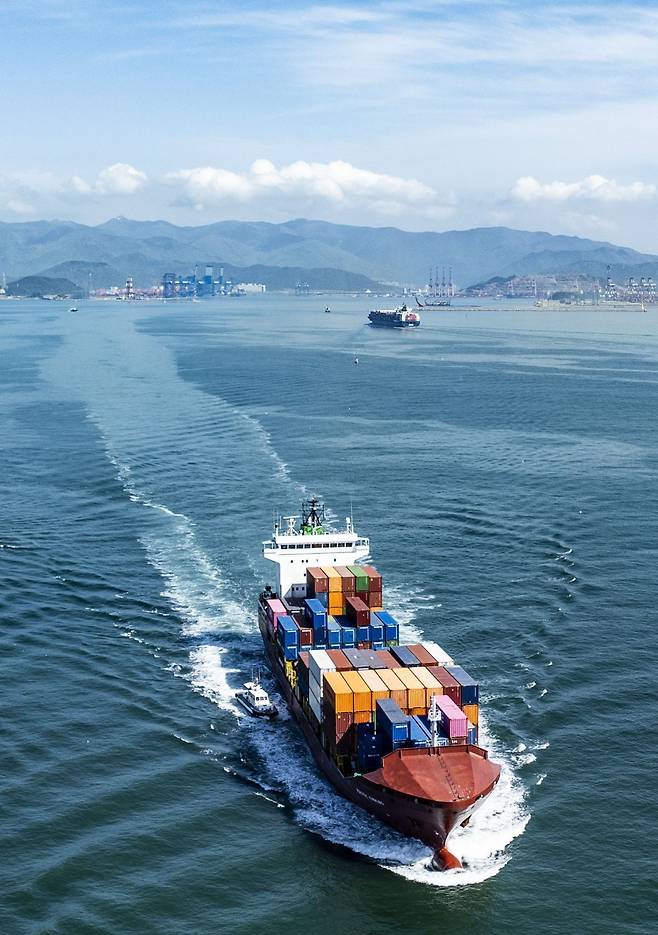 예인선의 도움을 받아 출항하는 컨테이너선.