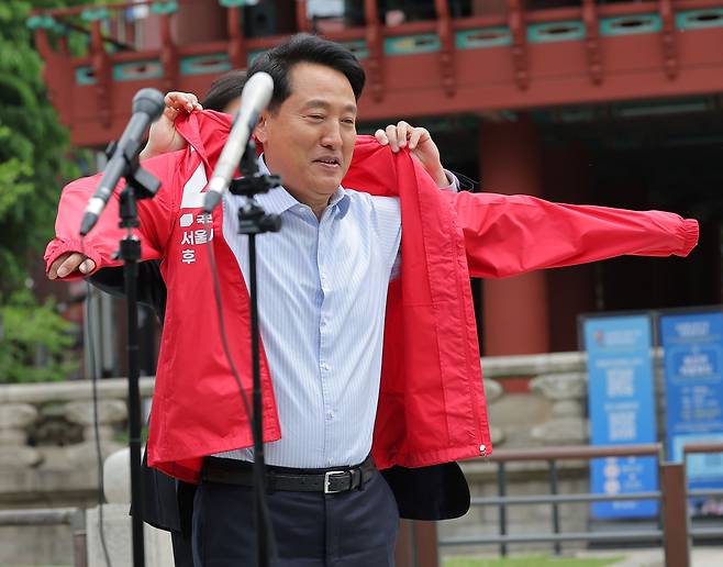 오세훈 국민의힘 서울시장 후보가 27일 서울 보신각 앞에서 출마 기자회견을 하기 전 빨간색 선거운동 점퍼를 입고 있다. [연합]