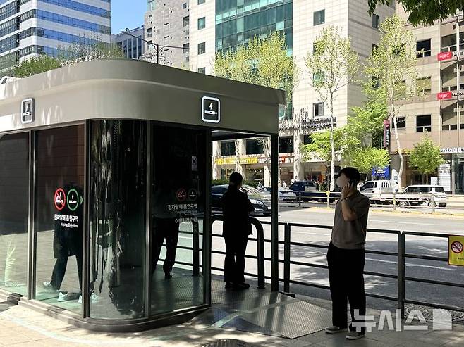 [서울=뉴시스] 김세은 인턴기자 = 24일 서울 강남구 테헤란로 금연거리에 위치한 흡연부스에서 담배를 피우고 있는 흡연자들의 모습. 2026.04.24.